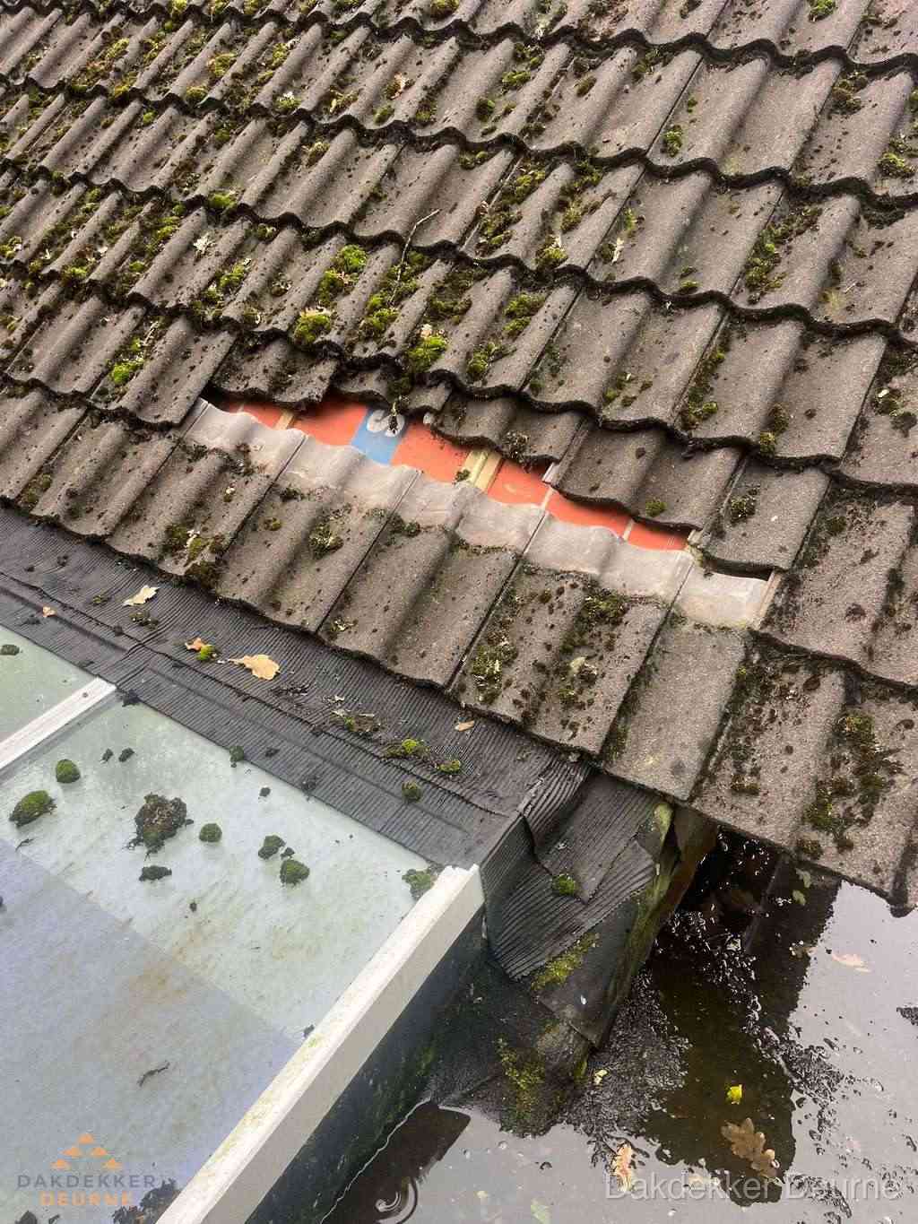 Beschadigd pannendak met ontbrekende dakpannen voor reparatie in Deurne