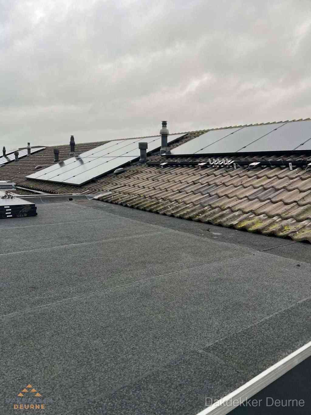Plat dak inspectie met bitumen bedekking naast schuin pannendak in Deurne