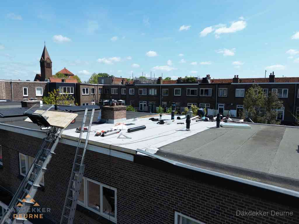 Dakdekkers aan het werk op plat dak in Deurne