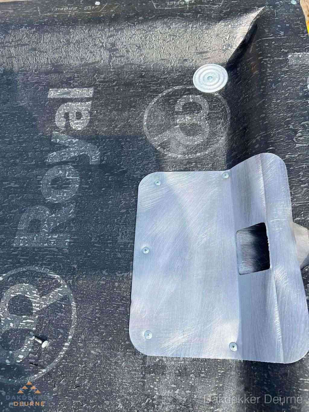 Dakdoorvoer met metalen afvoerplaat op bitumen dak in Deurne