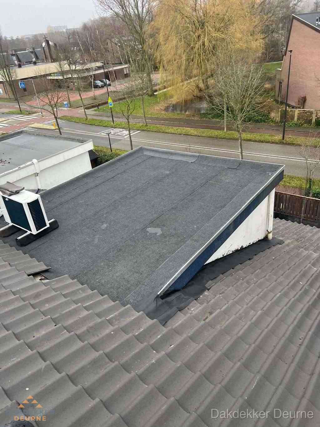 Plat dak met bitumen dakbedekking naast schuin pannendak in Deurne