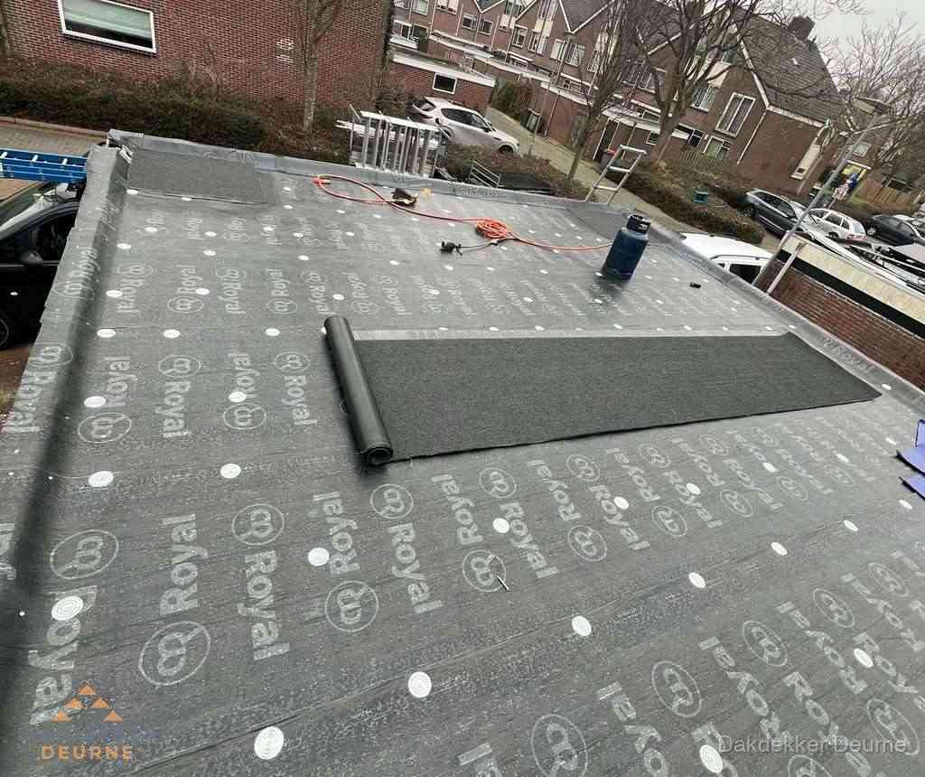 Dakdekker aan het werk met gasbrander op plat bitumen dak in Deurne